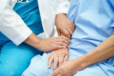 Klinikteki yaşlı kadın hastalarla ilgilenen, yardım eden ve onları cesaretlendiren doktor..