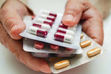 Asyalı yaşlı kadın elinde hap tutuyor, güçlü sağlıklı tıbbi konsept.. 