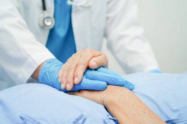 Doktor el ele tutuşuyor Asyalı yaşlı kadın hasta, hastanede yardım ve bakım.