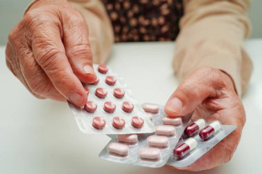 Asyalı yaşlı kadın elinde hap tutuyor, güçlü sağlıklı tıbbi konsept.. 
