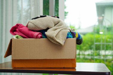 Gönüllüler için karton kutuda kıyafet bağışları.