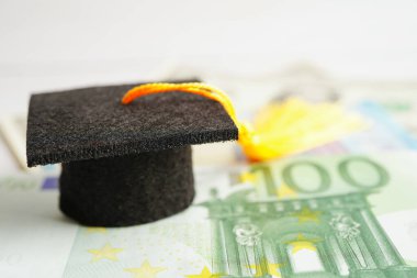 Avrupa ve ABD doları üzerindeki mezuniyet şapkası para, eğitim ücreti öğrenim öğrenimi öğretim konsepti.