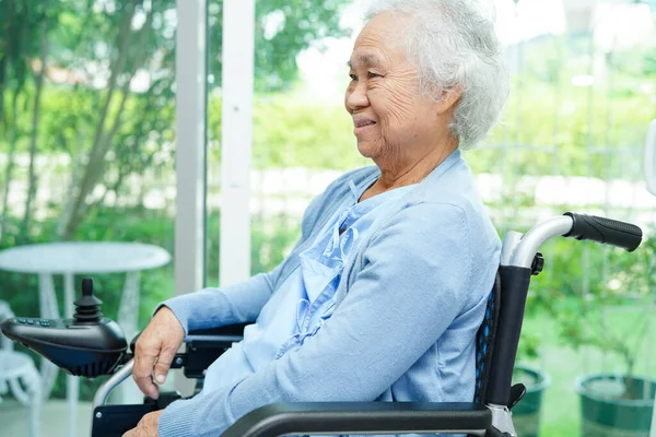 亚洲老年残疾妇女病人坐在公园的电动轮椅上 医学概念 — 图库照片
