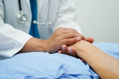 Doktor el ele tutuşuyor Asyalı yaşlı kadın hasta, hastanede yardım ve bakım.