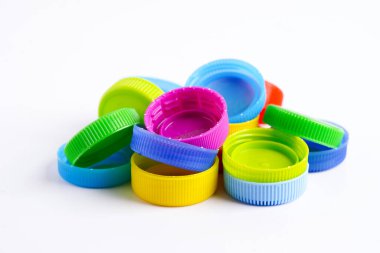 Plastik şişe kapakları beyaz arka planda geri dönüşüm için renklidir.