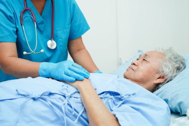 Doktor el ele tutuşuyor Asyalı yaşlı kadın hasta, hastanede yardım ve bakım.