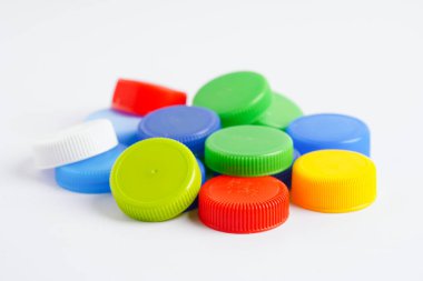 Plastik şişe kapakları beyaz arka planda geri dönüşüm için renklidir.