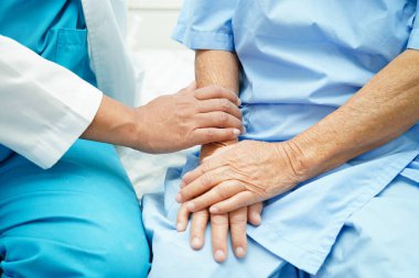 Klinikteki yaşlı kadın hastalarla ilgilenen, yardım eden ve onları cesaretlendiren doktor..
