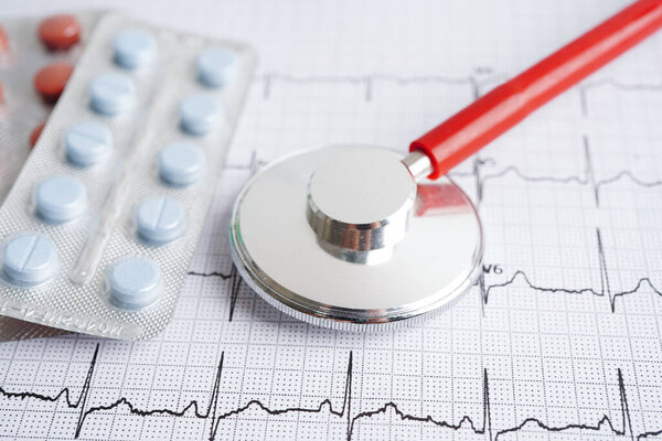Стетоскоп на электрокардиограмме (ЭКГ) с препаратом, сердечная волна, сердечный приступ, отчет кардиограммы.