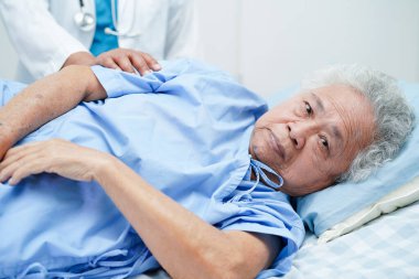 Klinikteki yaşlı kadın hastalarla ilgilenen, yardım eden ve onları cesaretlendiren doktor..