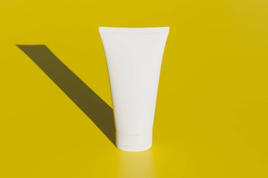 Sarı arka planda beyaz kozmetik tüpleri. Kozmetik için şablon, en az 3D biçim oluşturma.