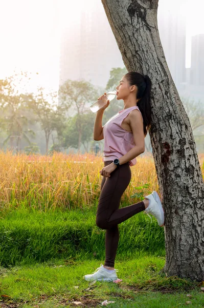 Parktaki antrenmandan sonra su içen güzel bir kadın..