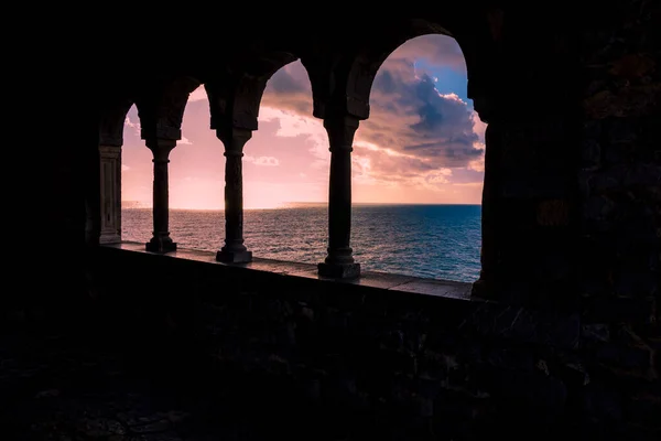 İtalya 'nın Liguria kentindeki Cinque Terre Ulusal Parkı' ndaki Porto Venere kalesinin penceresinden gün batımı. Denizin mavisiyle buluşan ılık renkler