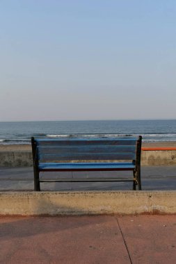 Deniz kenarında mavi bir bank.