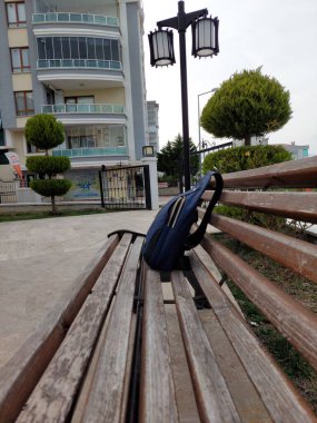 Parktaki bankta duran mavi çanta