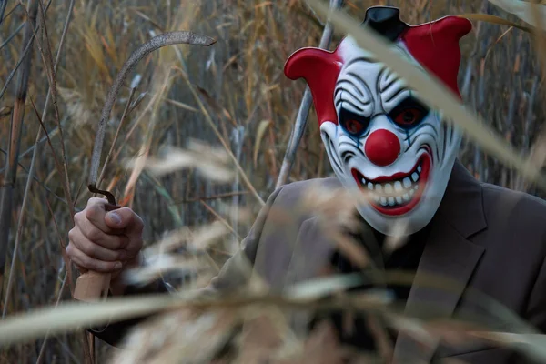 Palyaço maskeli bir katil ve çalılıklarda gizlenmiş bir orak kurbanını bekliyor.