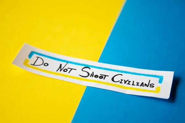 Mavi ve sarı arka plan, Ukrayna bayrağının renkleri Rus birliklerinin sivil halka saldırılarını temsil ediyor..