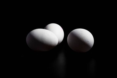 Siyah arkaplandaki beyaz yumurtaların fotoğrafları, beslenme grubu