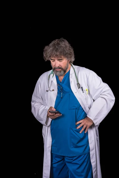 Vousatý Zralý Lékař Modrém Chirurgickém Obleku Bílém Plášti Při Pohledu — Stock fotografie