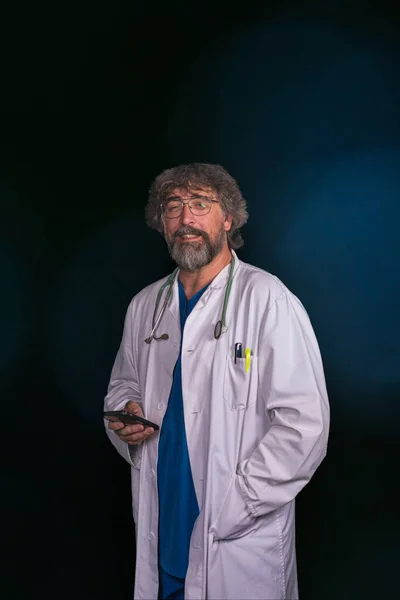 Vousatý Zralý Lékař Modrém Chirurgickém Obleku Bílém Plášti Při Pohledu — Stock fotografie