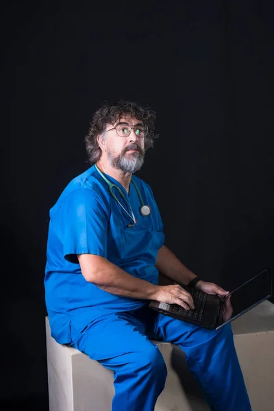 Vousatý Starší Lékař Oblečený Modrém Obleku Operačního Sálu Sedí Dřevěné — Stock fotografie
