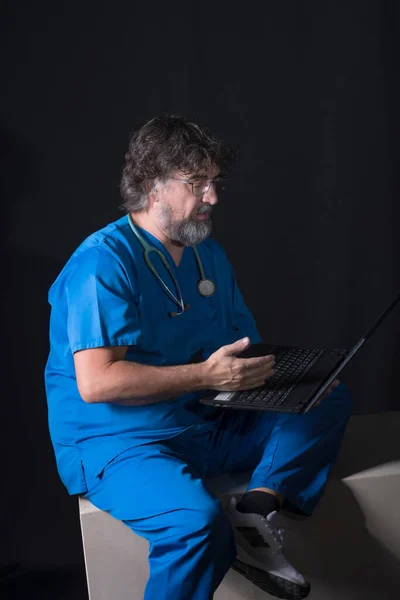 Vousatý Starší Lékař Oblečený Modrém Obleku Operačního Sálu Sedí Dřevěné — Stock fotografie