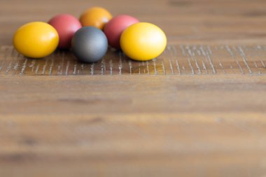 Parlak Paskalya yumurtaları güzel bir ahşap masada yatar.