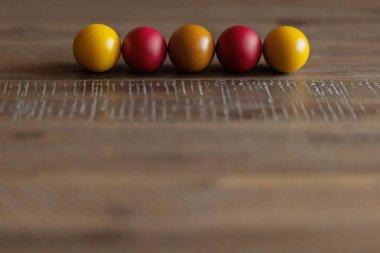 ahşap arka plan üzerinde beş parlak Paskalya yumurtaları