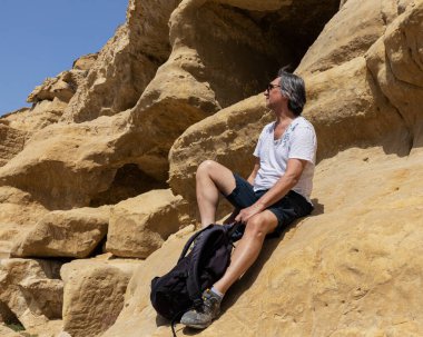 Mağaraların girişinde sırt çantalı bir sporcu, Yunanistan, Girit, Matala