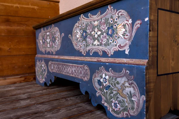 Antique painted wardrobe stands against the wall. Delicate flowers on a blue background. High quality photo
