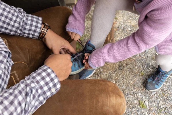 father helping daughter tie shoe lace. High quality photo