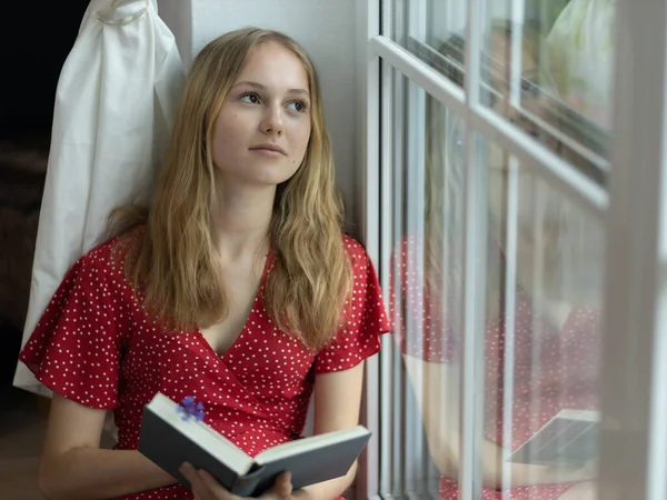 Young Girl Red Dress Sits Floor Window Book Her Hands —  Fotos de Stock