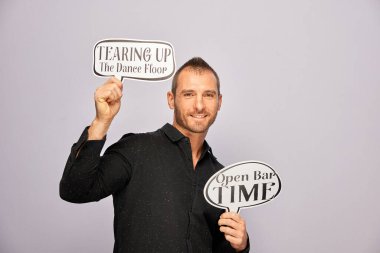 Erkek, fotoğraf kulübesinde poz veriyor.