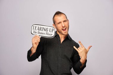 Erkek, fotoğraf kulübesinde poz veriyor.