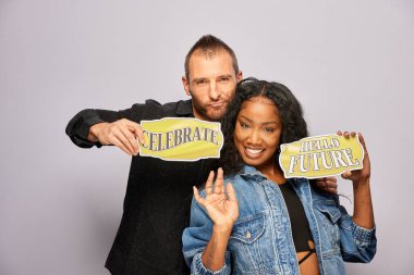 Kadın erkek fotoğraf kabini aksesuarlarıyla poz veriyor