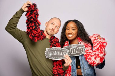 Kadın erkek fotoğraf kabini aksesuarlarıyla poz veriyor