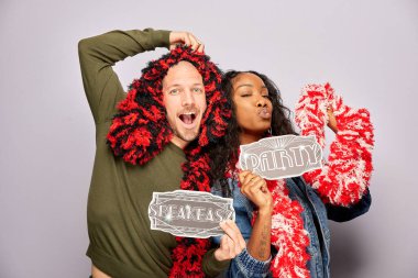 Kadın erkek fotoğraf kabini aksesuarlarıyla poz veriyor