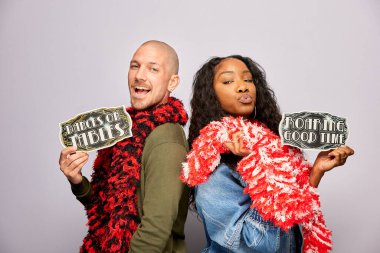 Kadın erkek fotoğraf kabini aksesuarlarıyla poz veriyor