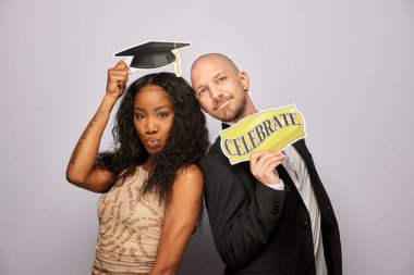 Kadın erkek fotoğraf kabini aksesuarlarıyla poz veriyor