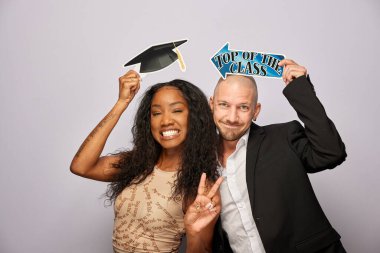 Kadın erkek fotoğraf kabini aksesuarlarıyla poz veriyor