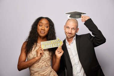 Kadın erkek fotoğraf kabini aksesuarlarıyla poz veriyor