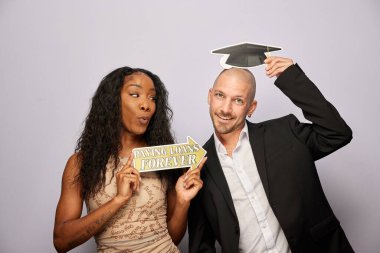 Kadın erkek fotoğraf kabini aksesuarlarıyla poz veriyor