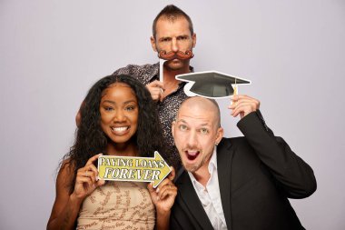 Kadın erkek fotoğraf kabini aksesuarlarıyla poz veriyor