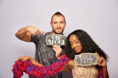 Kadın erkek fotoğraf kabini aksesuarlarıyla poz veriyor