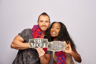 Kadın erkek fotoğraf kabini aksesuarlarıyla poz veriyor