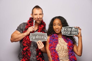 Kadın erkek fotoğraf kabini aksesuarlarıyla poz veriyor