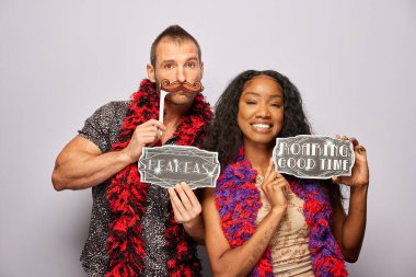 Kadın erkek fotoğraf kabini aksesuarlarıyla poz veriyor