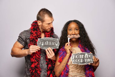 Kadın erkek fotoğraf kabini aksesuarlarıyla poz veriyor