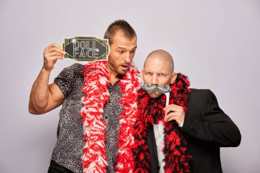 Erkek poz veriyor ve elinde aksesuar var.