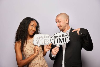 Kadın erkek poz veriyor ve elinde aksesuar var.